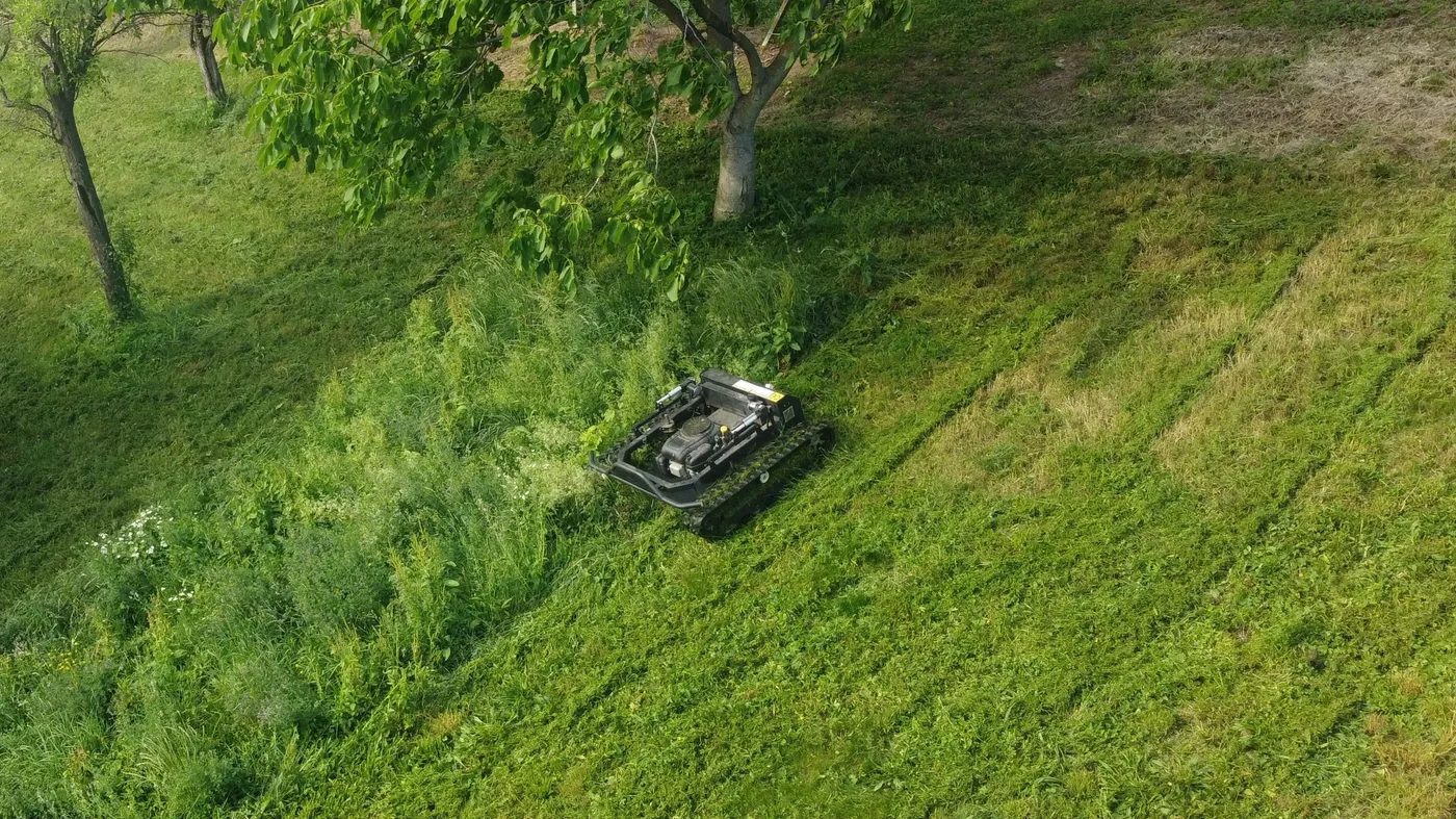 Pogled iz zraka na kosilnico SMG-H900L pri košnji strmega, zaraslega pobočja